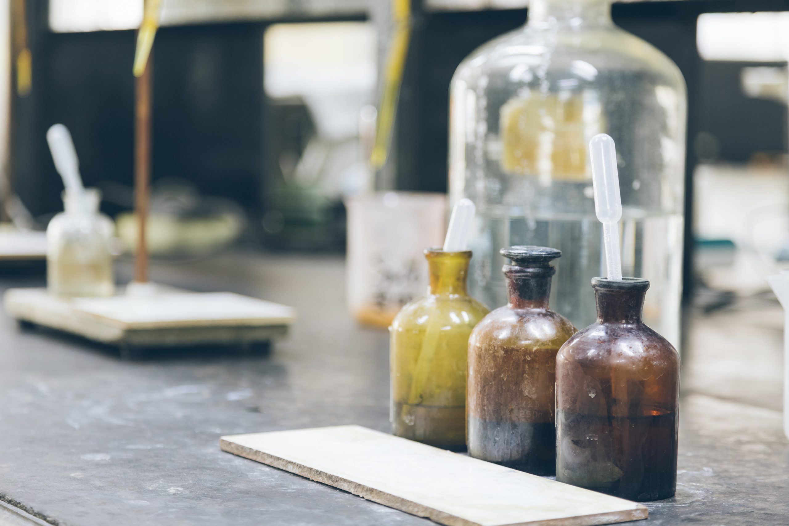 detail shot of beakers and equipment on table in factory laboratory.